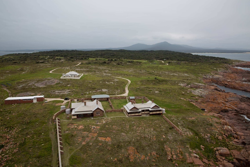 Four buildings stand on a rugged island.