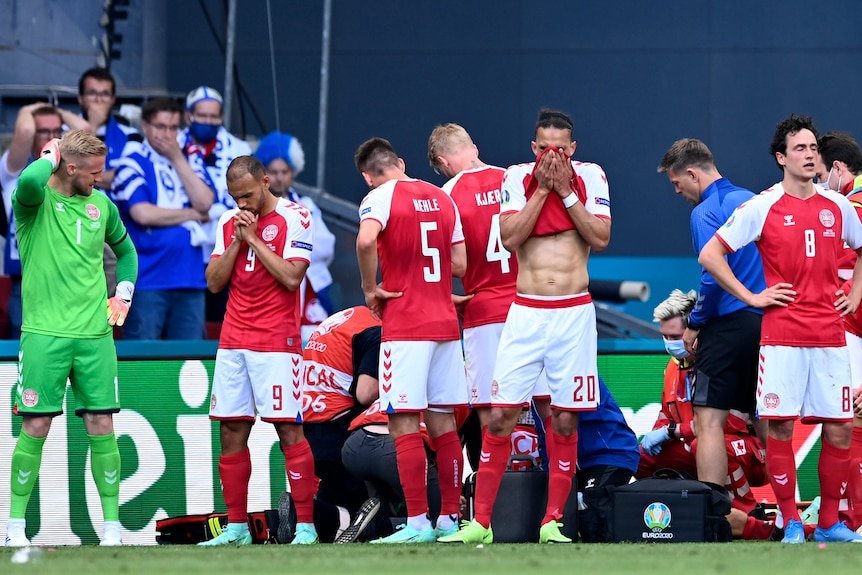 Denmark players react while medics assist Christian Eriksen