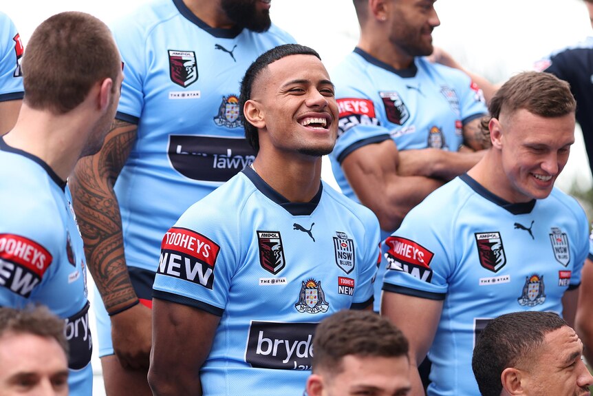 NSW Blues players pose for a team photo before State of Origin game one, with Stephen Crichton laughing in the middle.