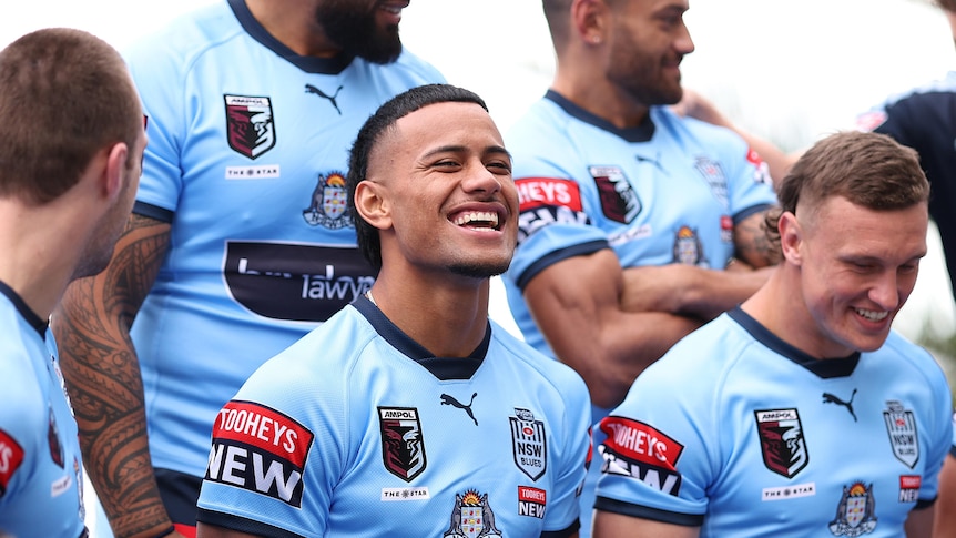 NSW Blues players pose for a team photo before State of Origin game one, with Stephen Crichton laughing in the middle.