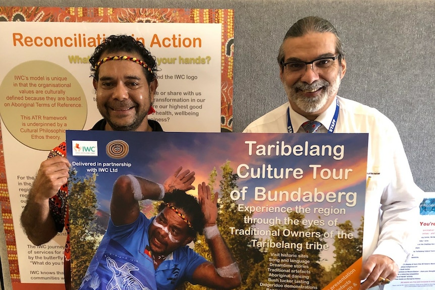 Two men holding a sign at the bundaberg Indigenous wellbeing centre