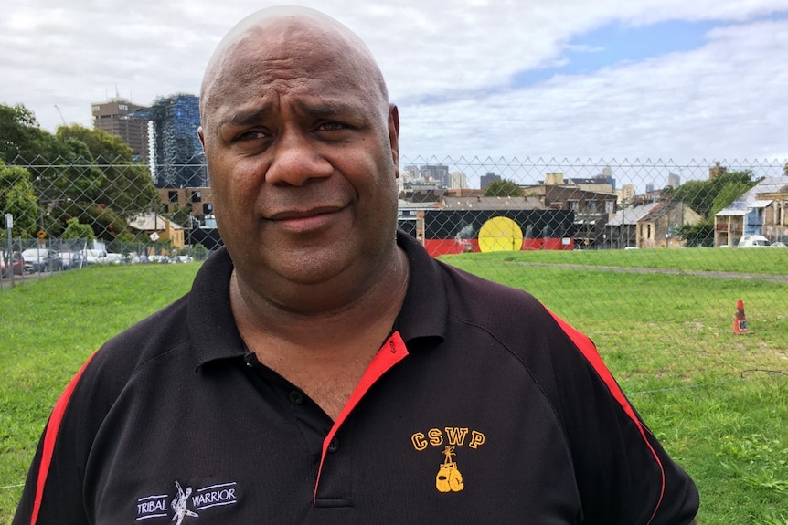 A man stands in front of Redfern's The Block.