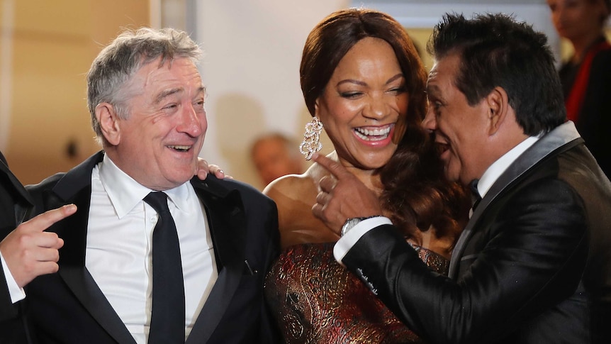 Actor Robert de Niro and his wife Grace Hightower de Niro laugh as Panamanian boxer Roberto Duran speaks.