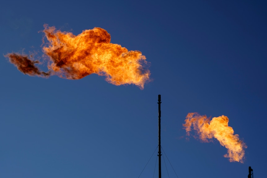 Flares burn off methane and other hydrocarbons at an oil and gas facility in Lenorah, Texas