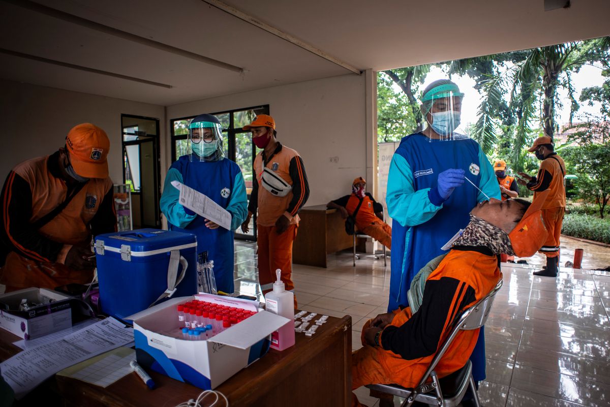 a nurse takig a swab for COVID from a lady in Jakarta.