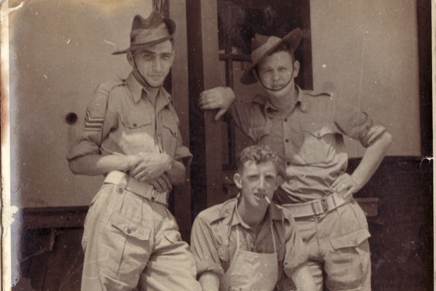 An old black and white photo of Australian Soldiers after WW2 in Japan. One soldier is sitting down wearing an apron.