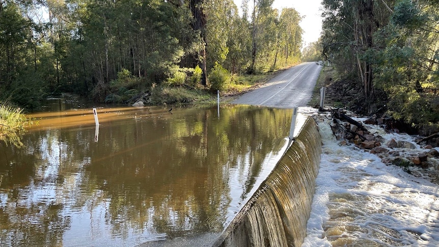 Water flowing over a road on a creek causeway in the country