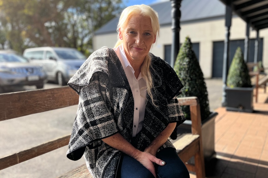 A blonde woman sitting on a bench