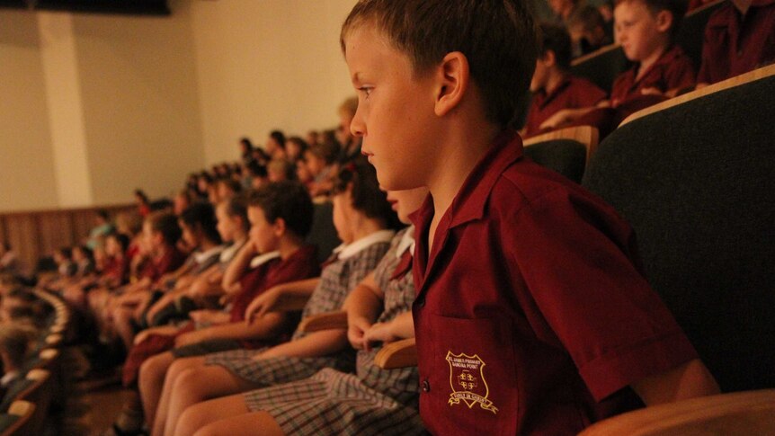 A primary school child watches an orchestral performance
