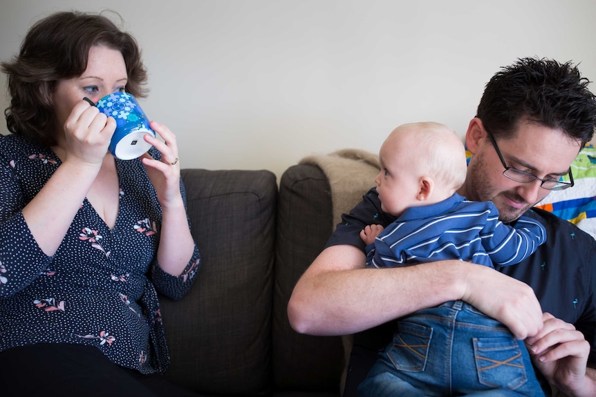 Mother Kira Longfield, husband Jared cuddle their baby William on the couch in their Pakenham home.