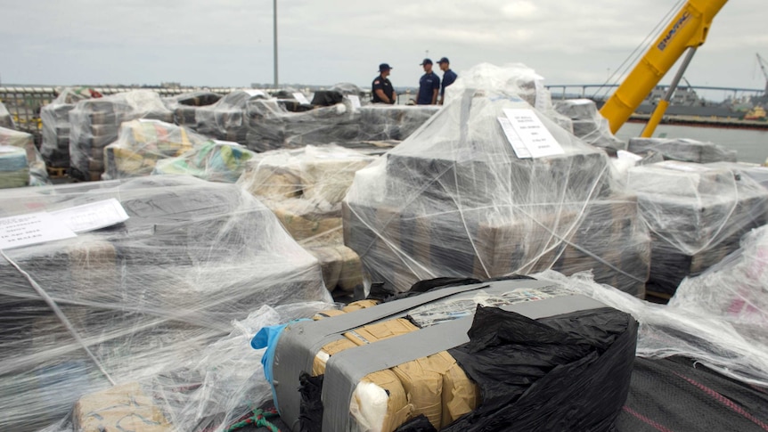 Armed crew members of the US Coast Guard Cutter Stratton watch as more than 32 metric tons of cocaine worth US$1 billion is unloaded