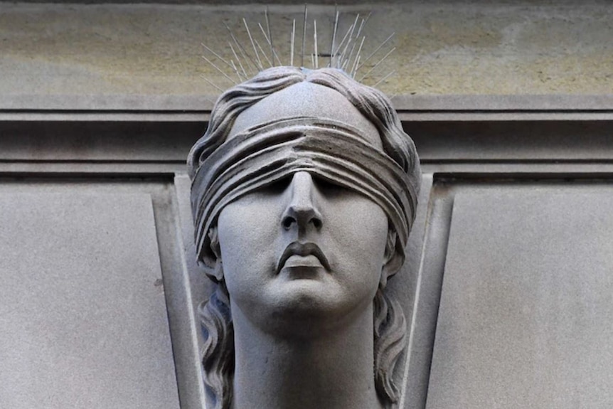 A stone statue of a woman wearing a blindfold