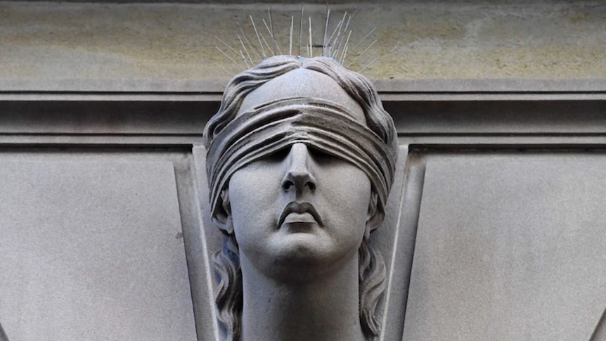 A stone statue of a woman wearing a blindfold