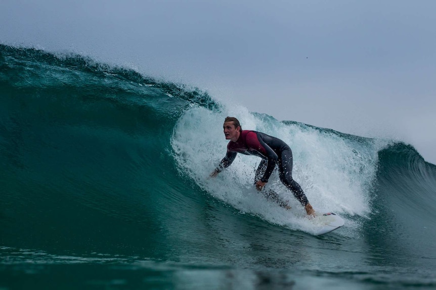 A man in a wetsuit surfing a wave