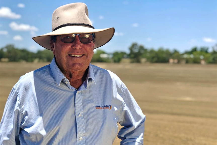 Barcaldine Mayor Rob Chandler smiles wearing a hat outside.