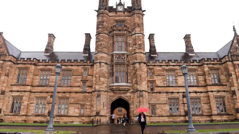 Students walk around the University of Sydney campus on a rainy day.