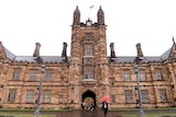 Students walk around the University of Sydney campus on a rainy day.