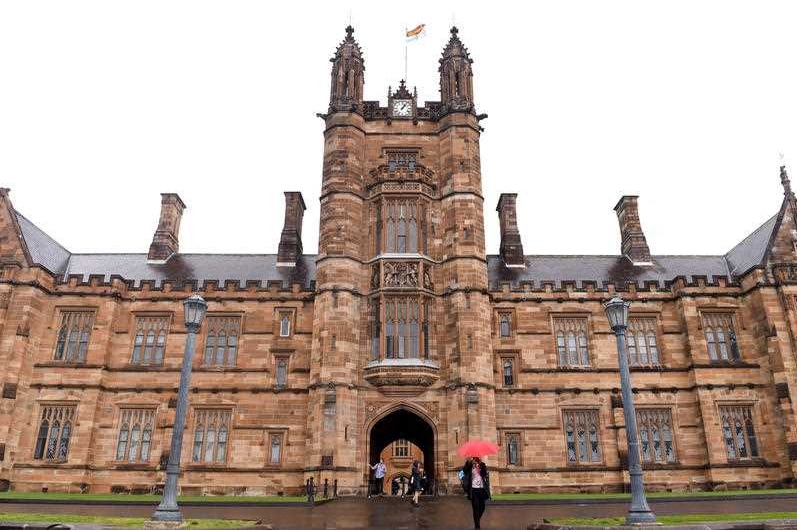 Students stroll around the University of Sydney campus on a rainy day.