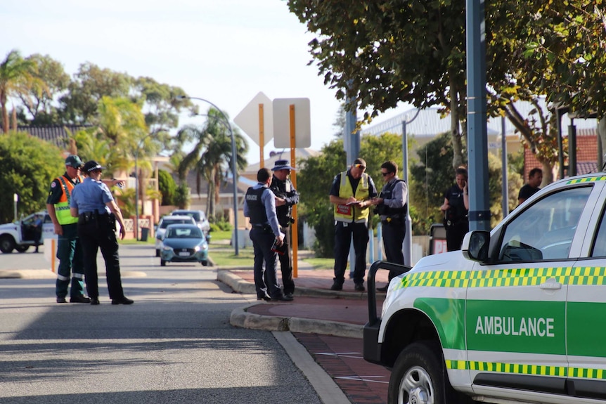 La police et une ambulance dans une rue.