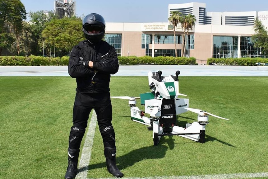 A pilot stands beside the Hoversurf Scorpion, a vehicle commissioned by Dubai police.