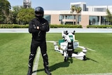 A pilot stands beside the Hoversurf Scorpion, a vehicle commissioned by Dubai police.