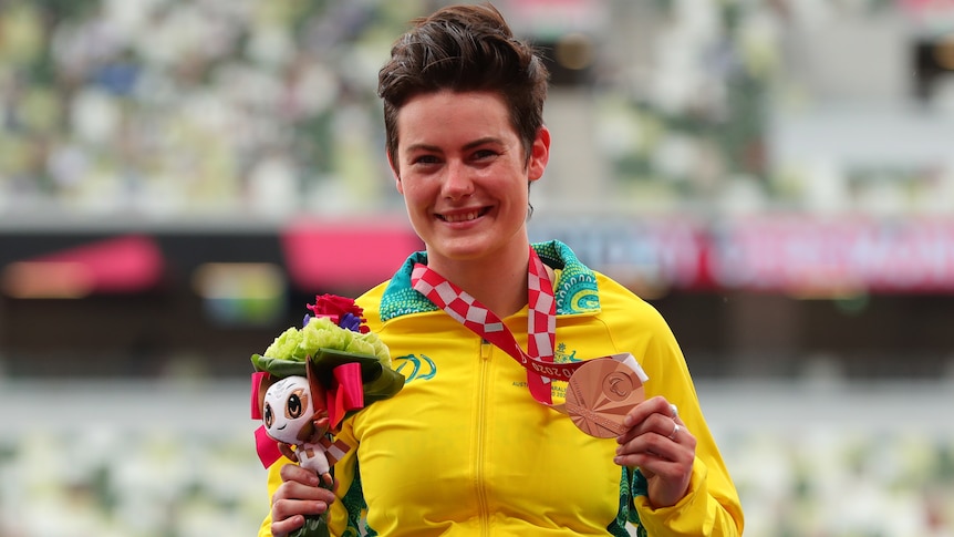 Robyn Lambird smiles and holds a bronze medal around her neck.
