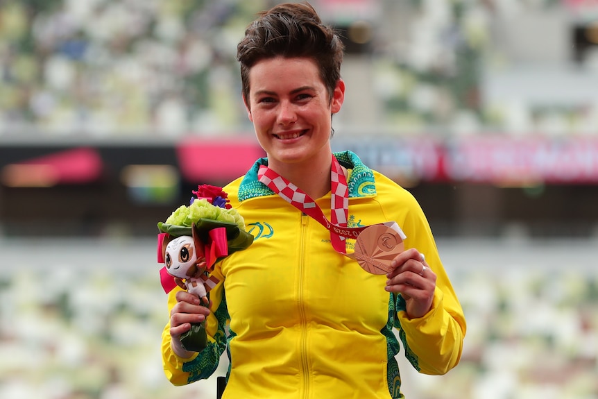 Robyn Lambird smiles and holds a bronze medal around her neck.