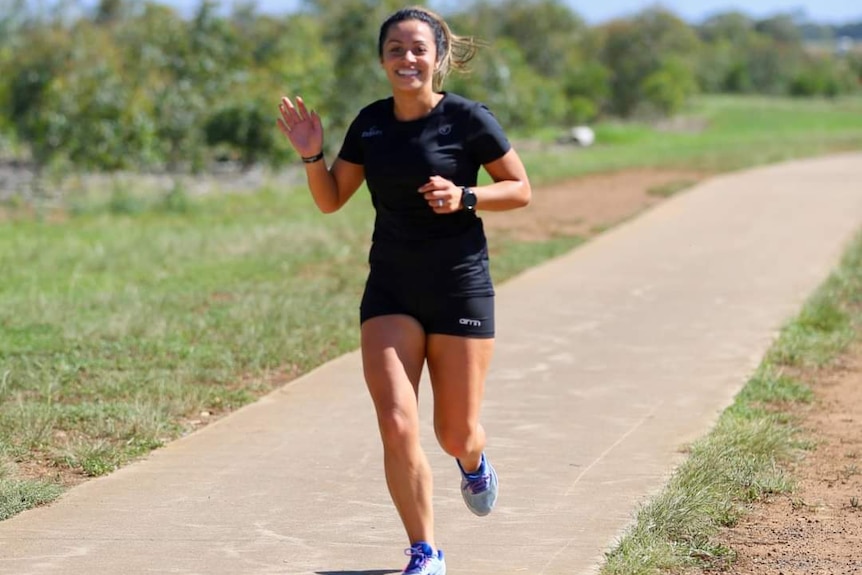A woman runs and smiles.