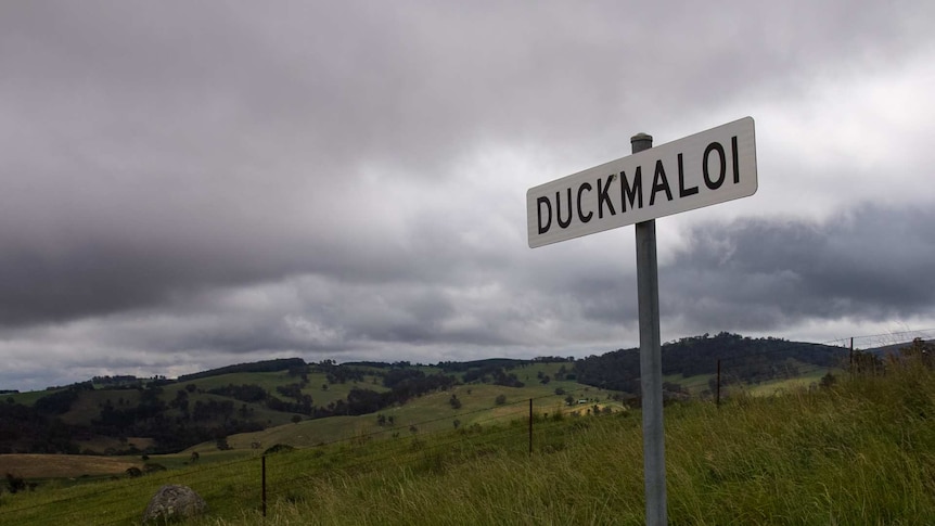 A sign saying Duckmaloi in front of rolling rural hills