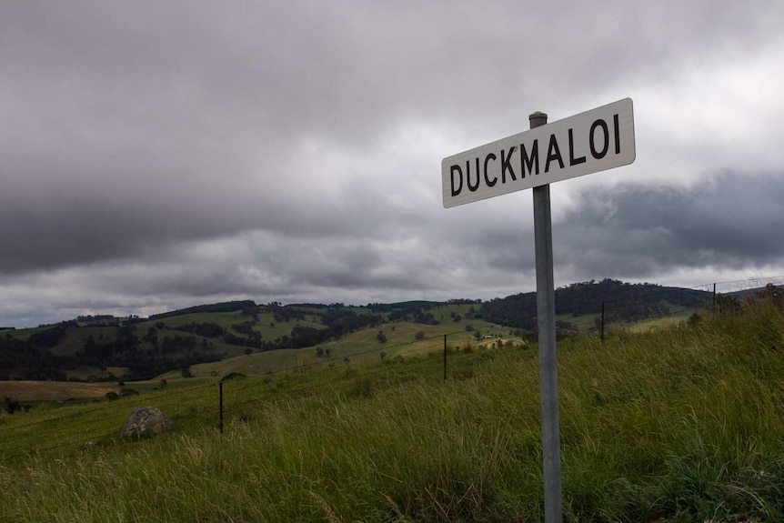 A sign saying Duckmaloi in front of rolling rural hills