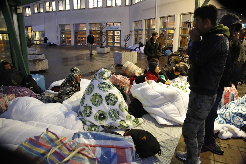 Asylum seekers sleep on the ground outside the entrance to Sweden's Migration Agency.