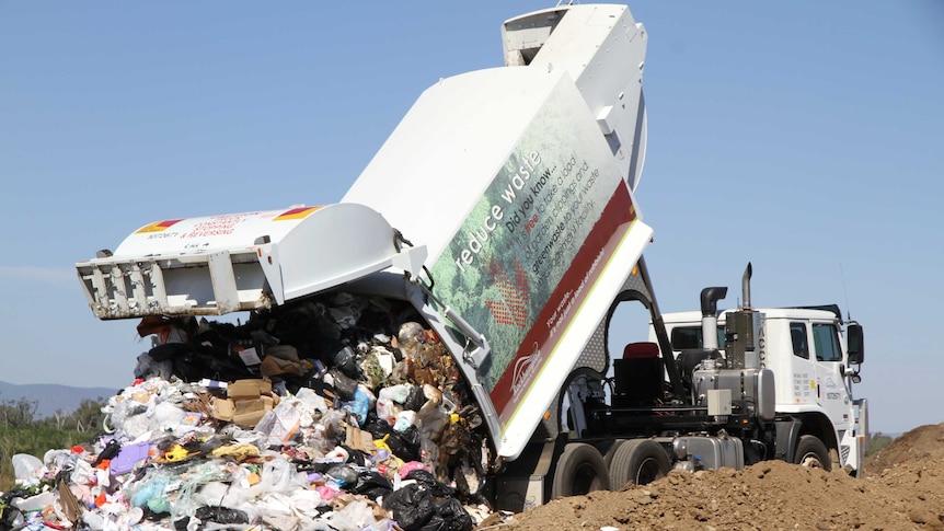 Rubbish truck tipping garbage at landfill