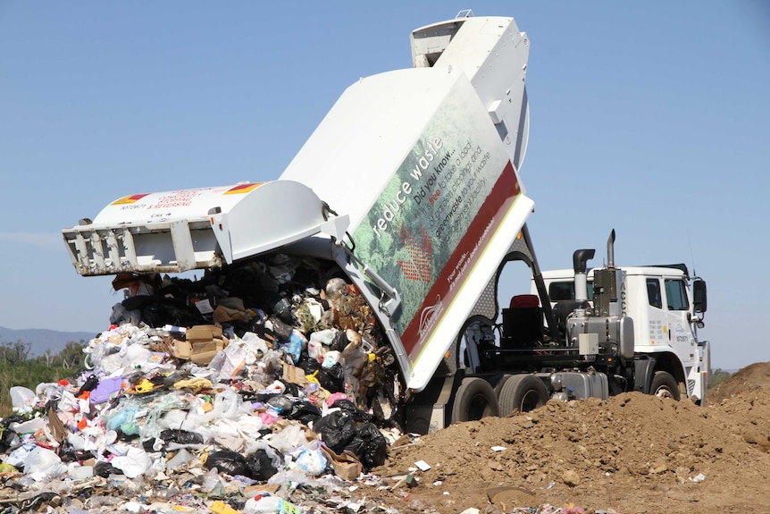 Camion à ordures basculant les ordures à la décharge