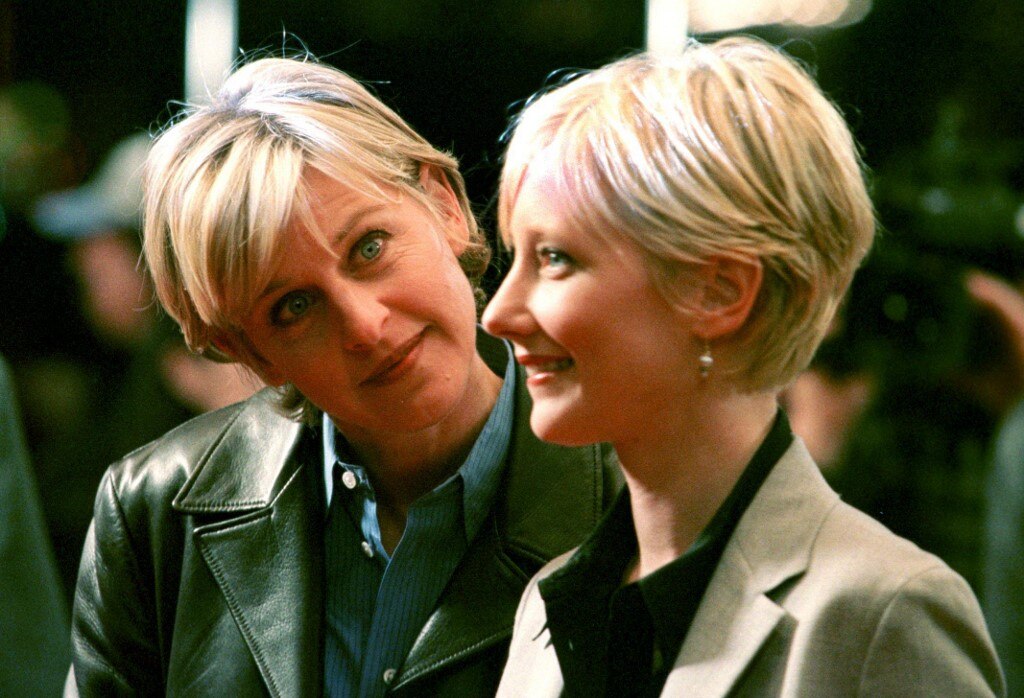 Ellen Degeneres cocks her head to the side and looks at Anne Heche as Heche smiles