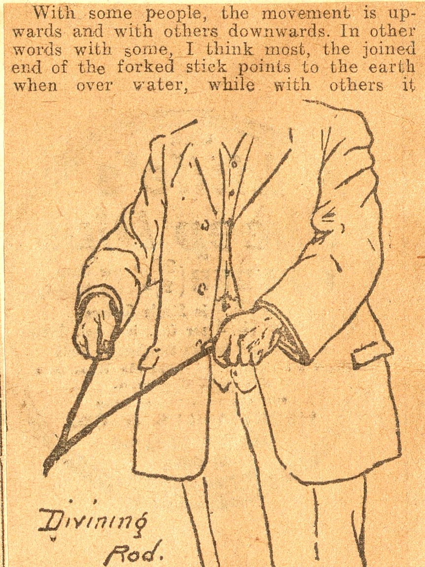 A story on water divining, with a line illustration of a man in a suit holding two sticks pointing forward in a V shape. 