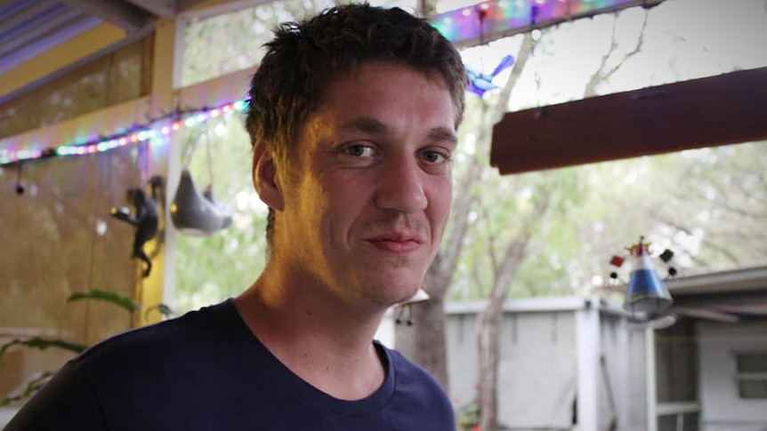 A man in an outdoor shed setting