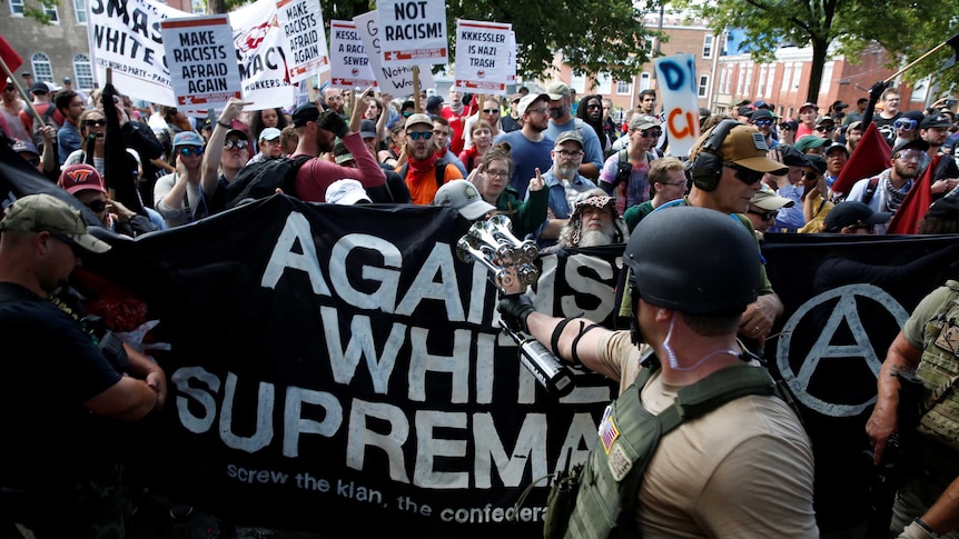 A group of protesters carrying anti-racism signs.