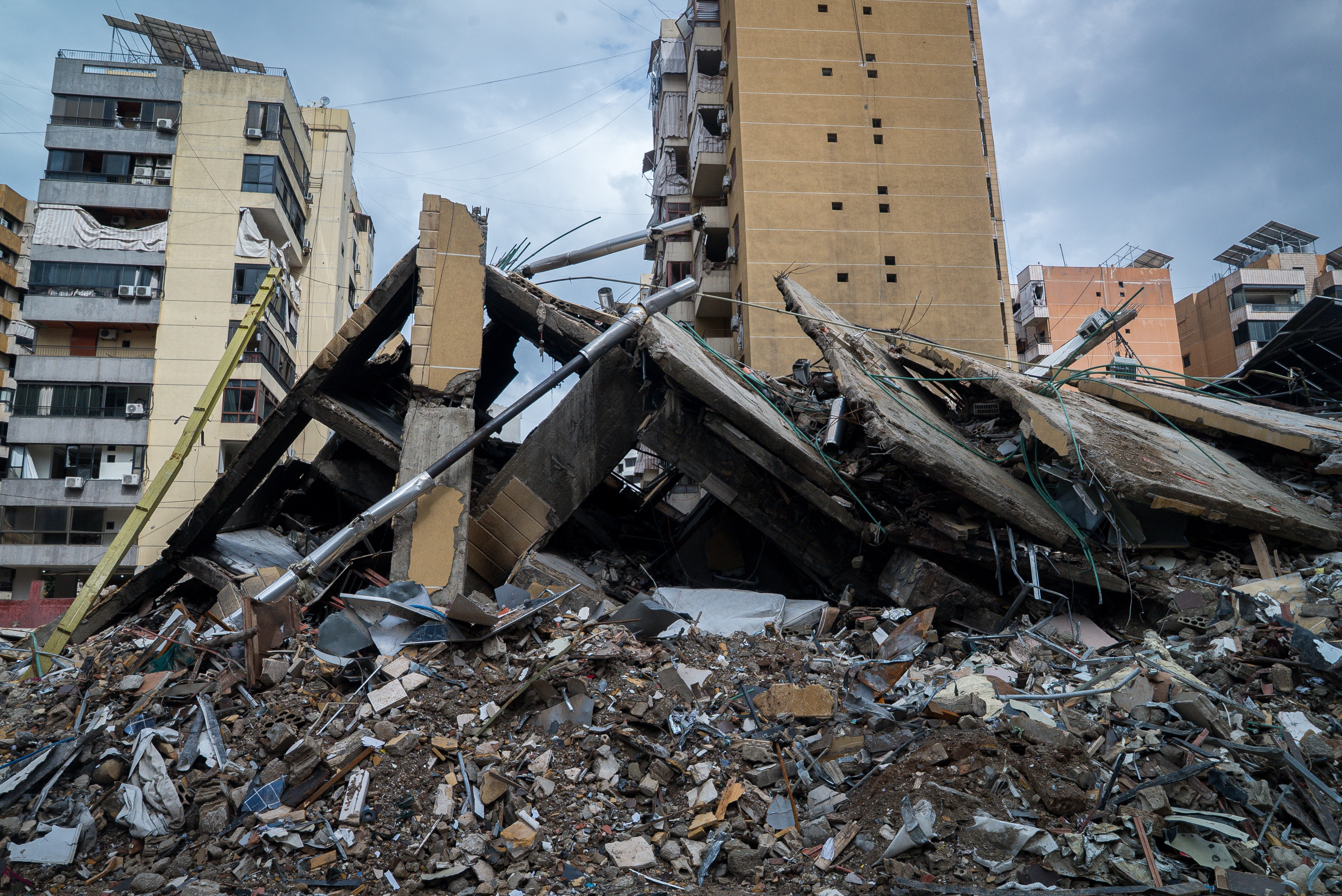 Escombros y edificio derrumbado con dos edificios en pie al fondo
