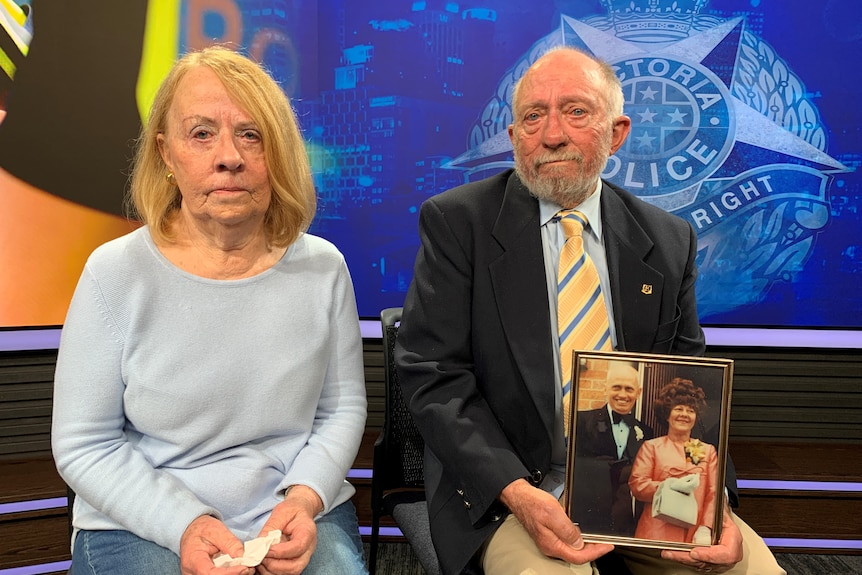 A man and woman hold a photo of Doris McCartney.