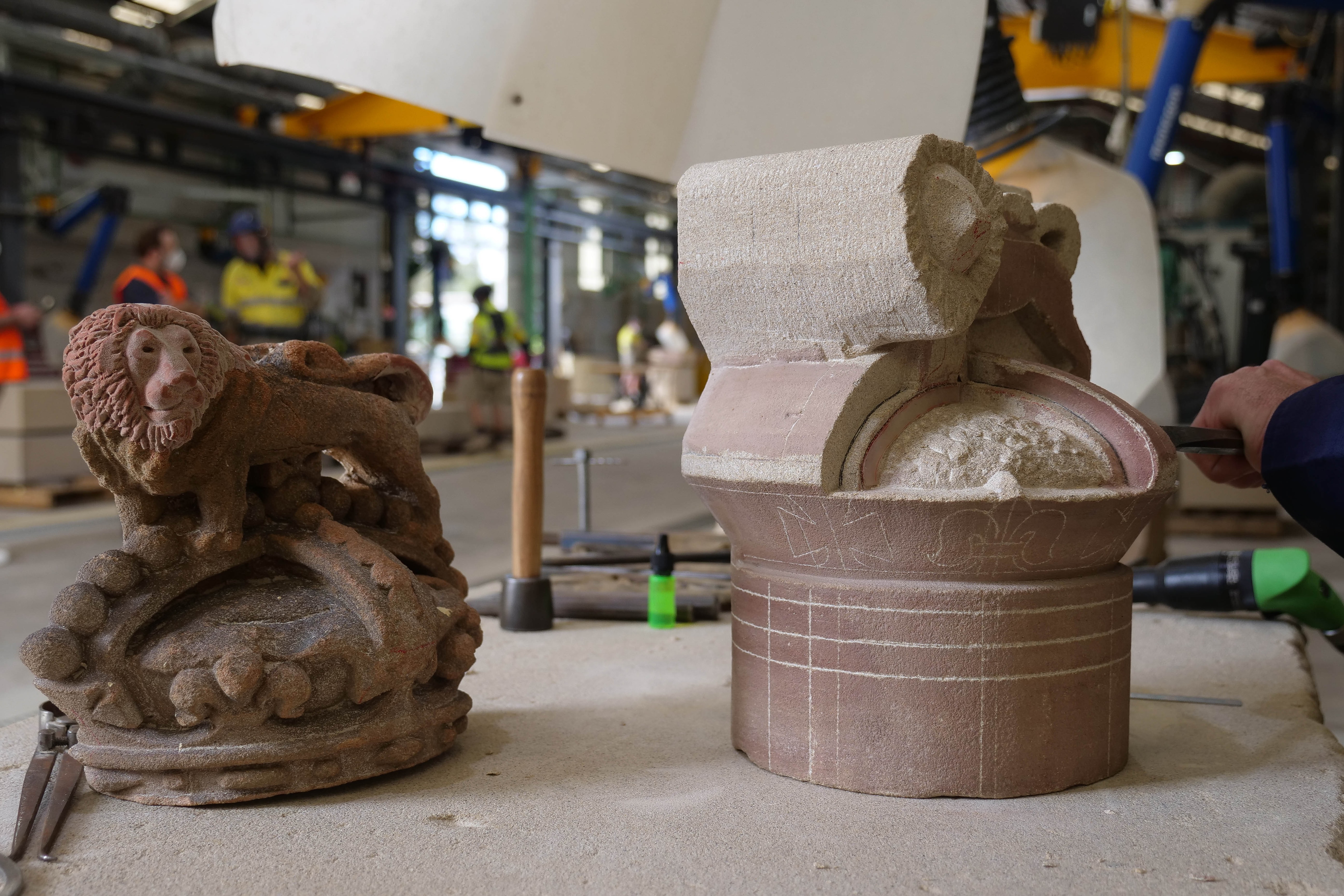 a sandstone model of a lion atop a crown on a benchtop
