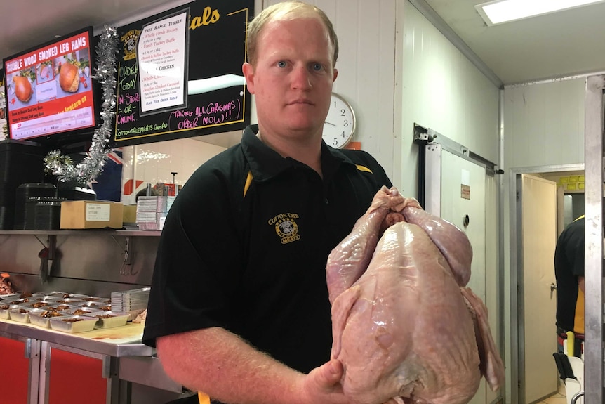 A man holds a dressed turkey ready for Christmas dinner