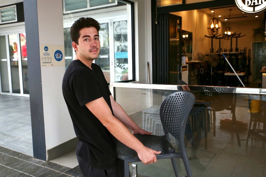 a man stacking chairs in a restaurant