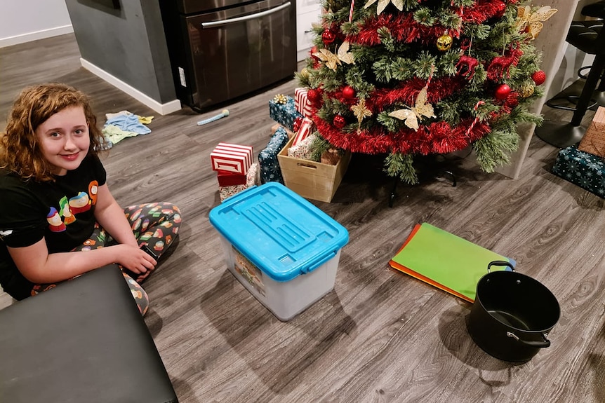 Ella Richardson with the copperhead snake in a container and the pot she trapped it under.