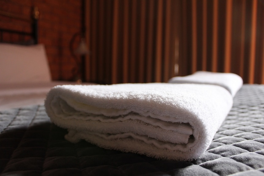 Towels on the bed of a hotel room.