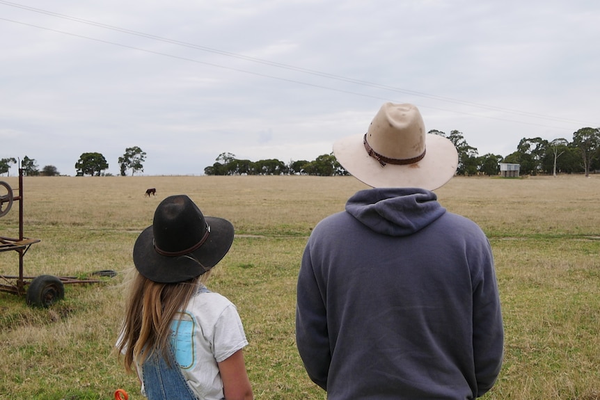 two people looking out at a farm