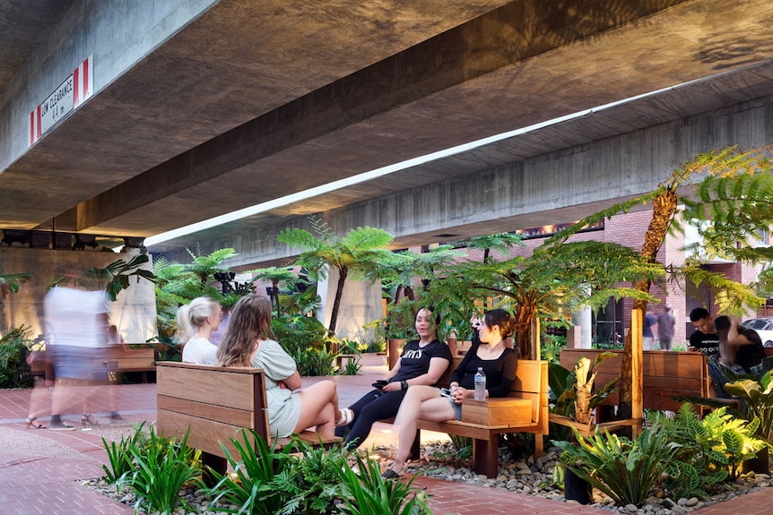 People sitting on yellow seat under concrete roof