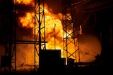 a firefighter blasts flames engulfing the power plant