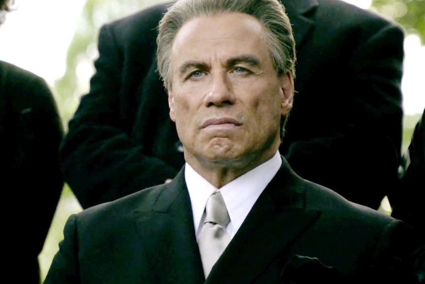 John Travolta sits and stares in Gotti.