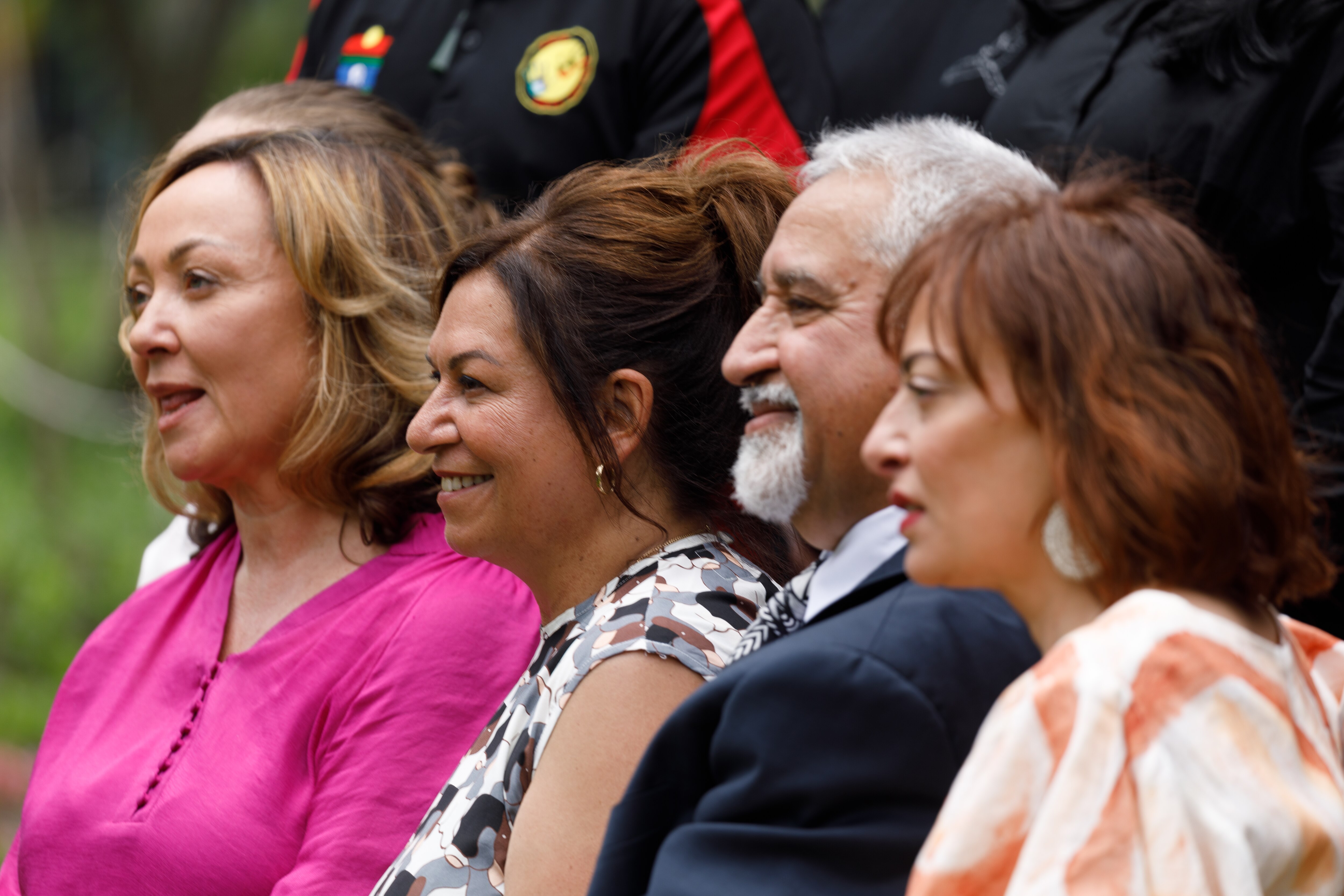 Four of the Treaty Authority members smile as they pose for a group photos outdoors.