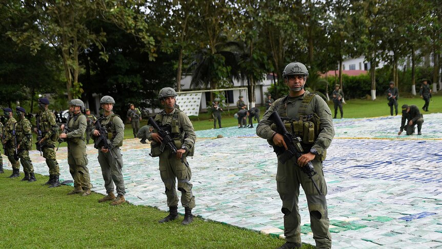Colombian police and soldiers guard more than 12 tons of seized cocaine